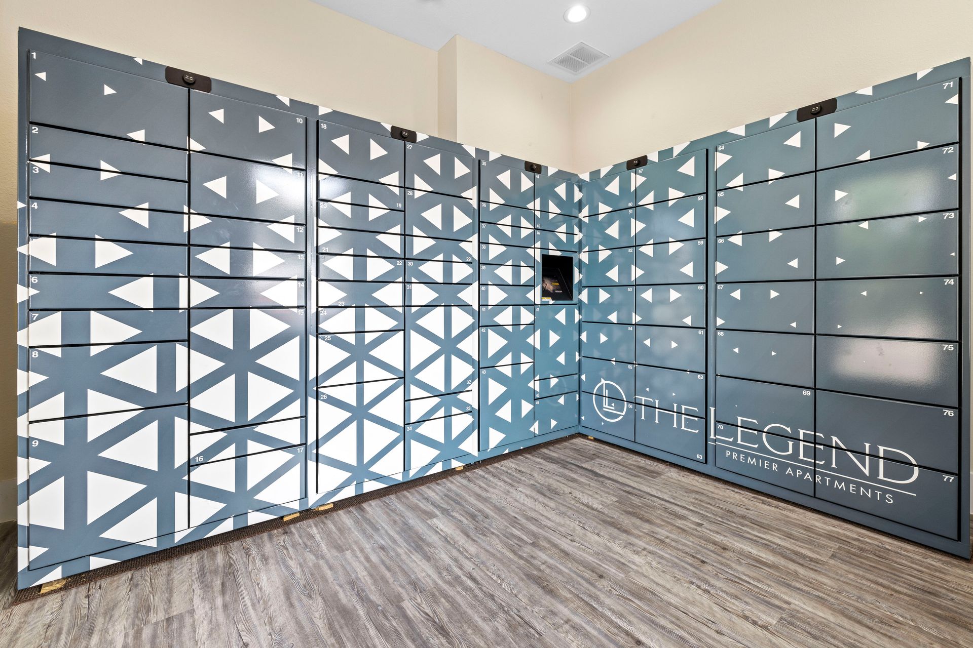 A room with a table and chairs and computers on the desks.