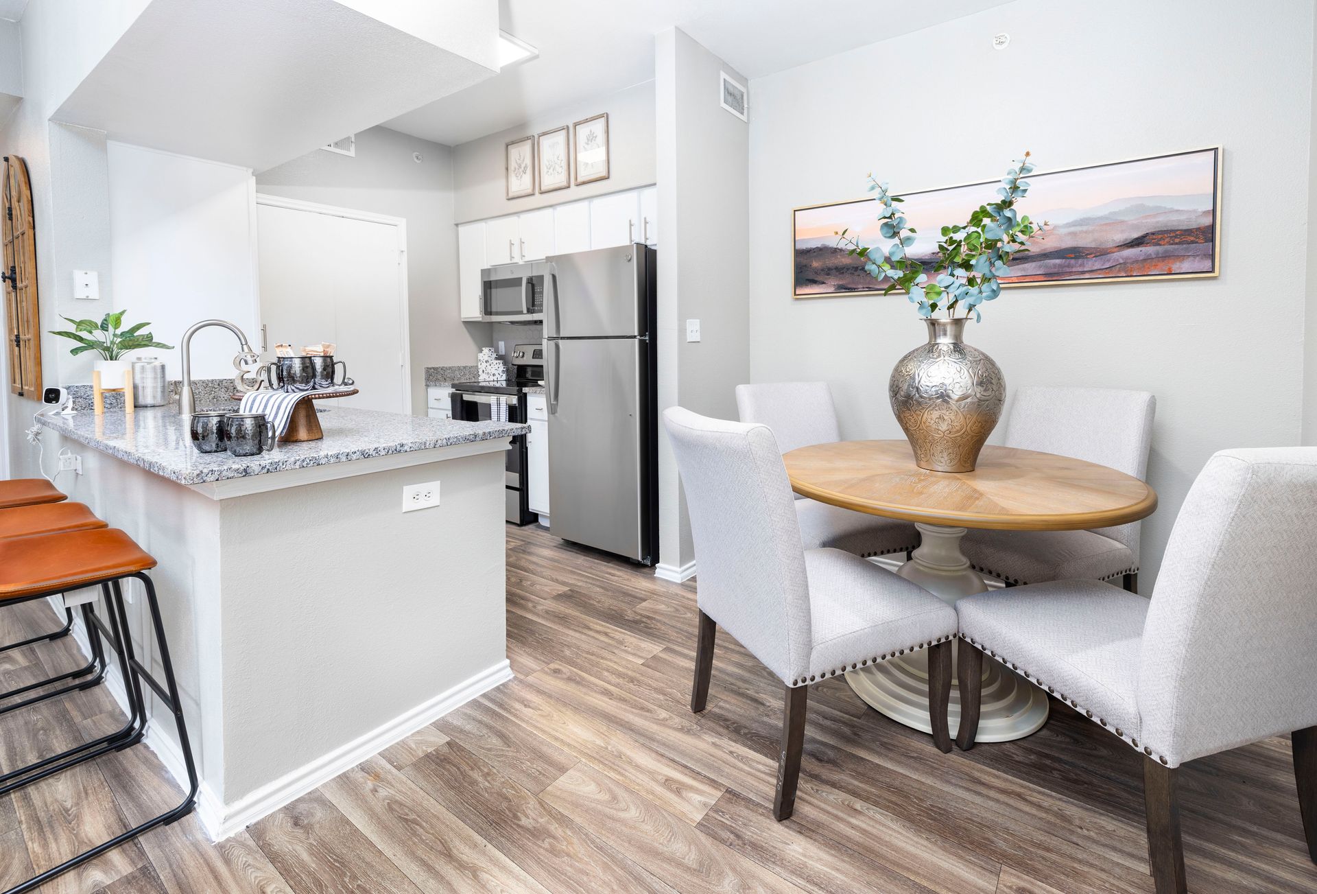 A kitchen with a stove , refrigerator , microwave and sink.