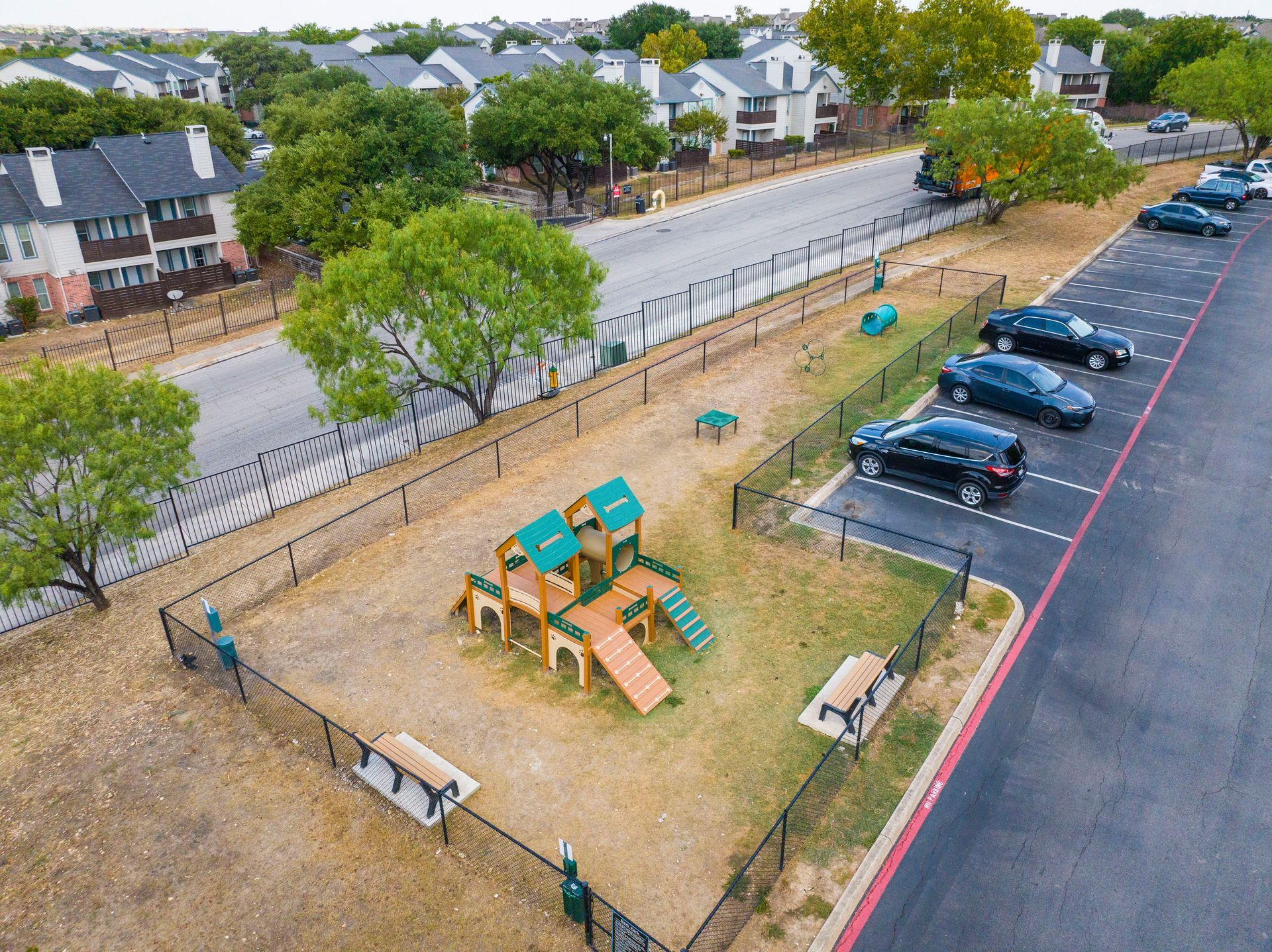An aerial view of a dog park in a parking lot.