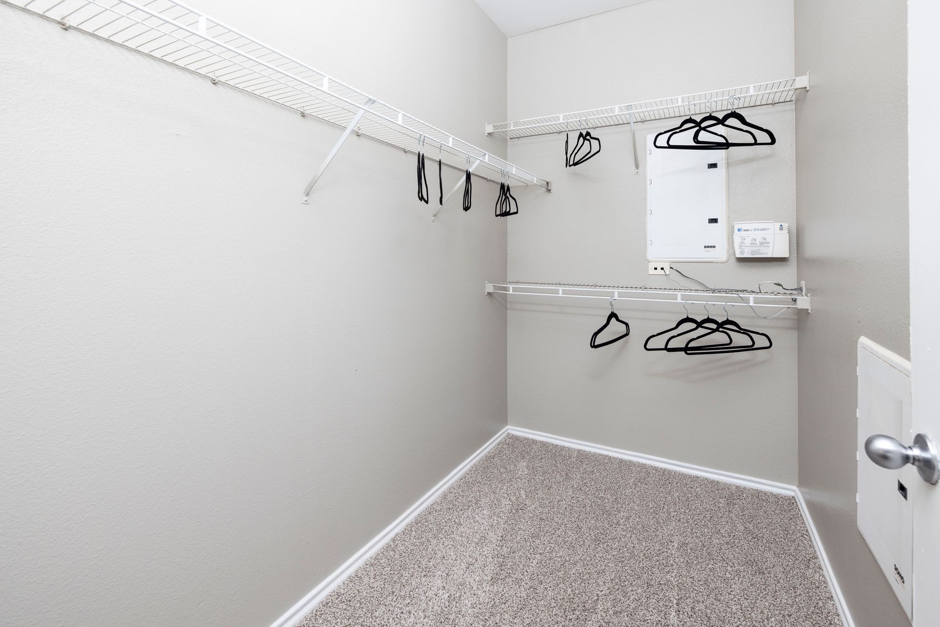 A walk in closet with a lot of clothes hanging on the racks.