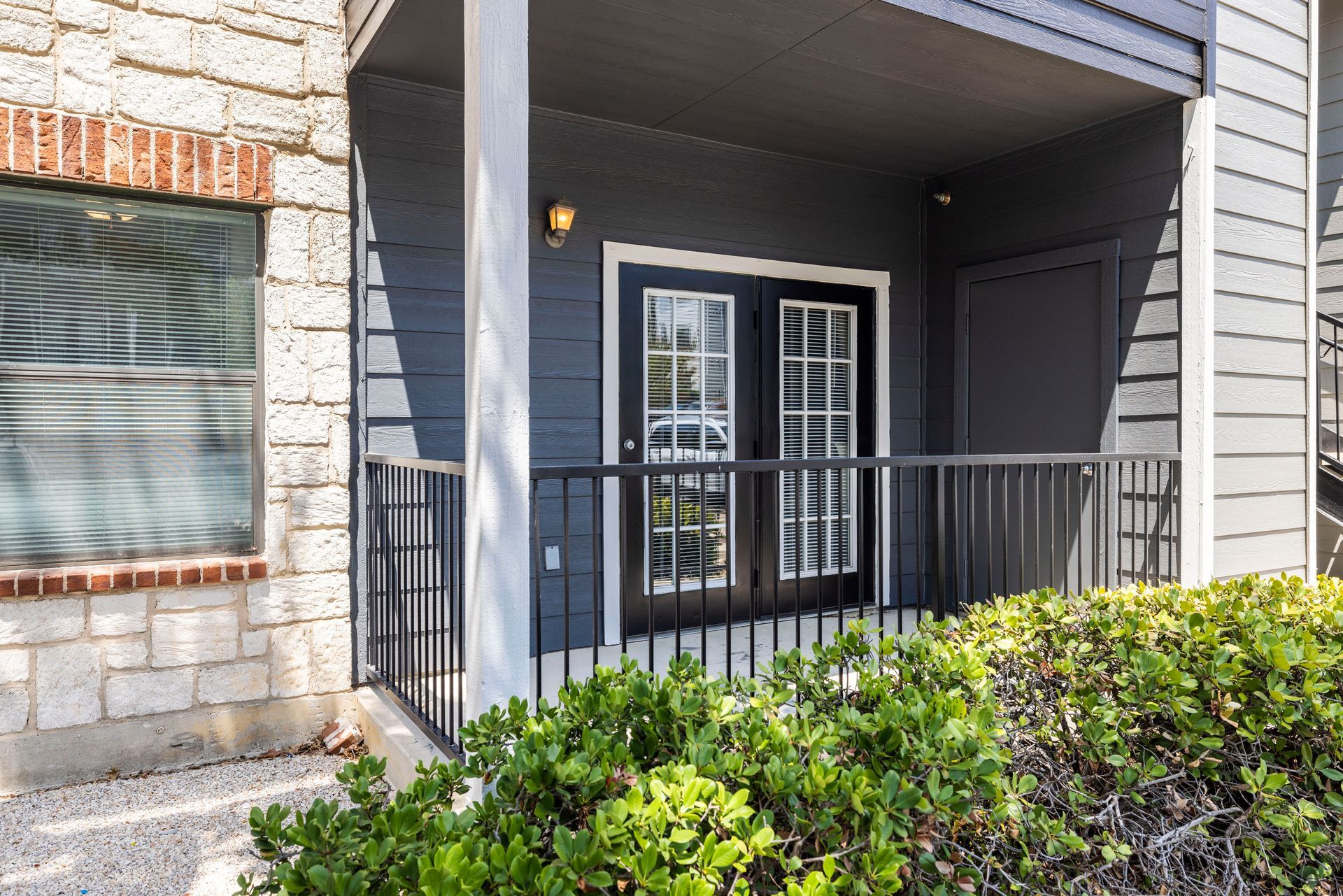 A balcony with sliding glass doors and a railing in front of a house.