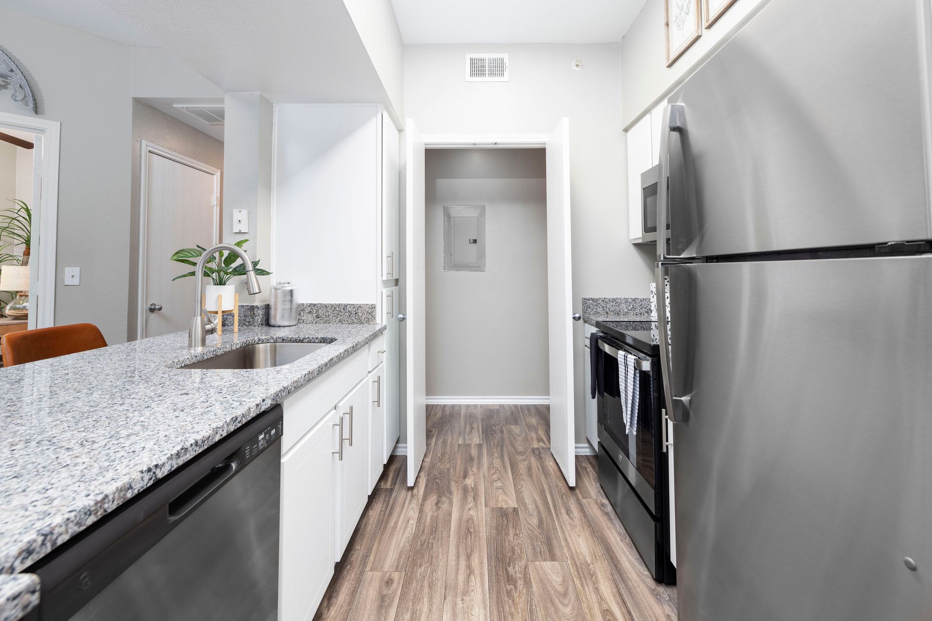 A kitchen with stainless steel appliances and granite counter tops.
