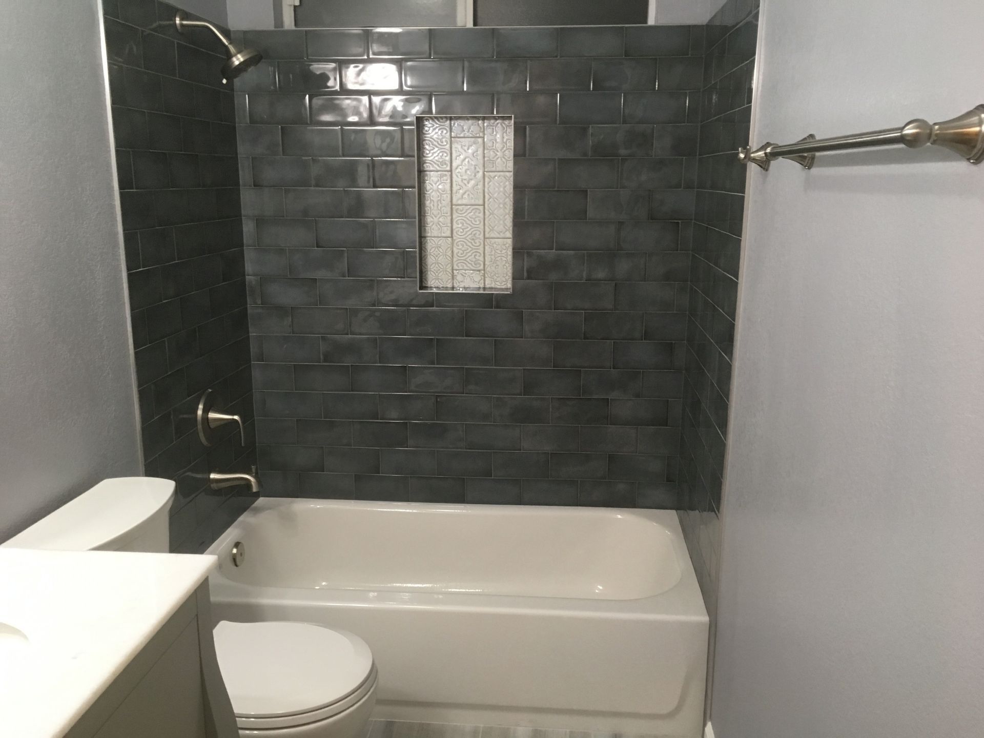 A bathroom with a bathtub , toilet , sink and shower.