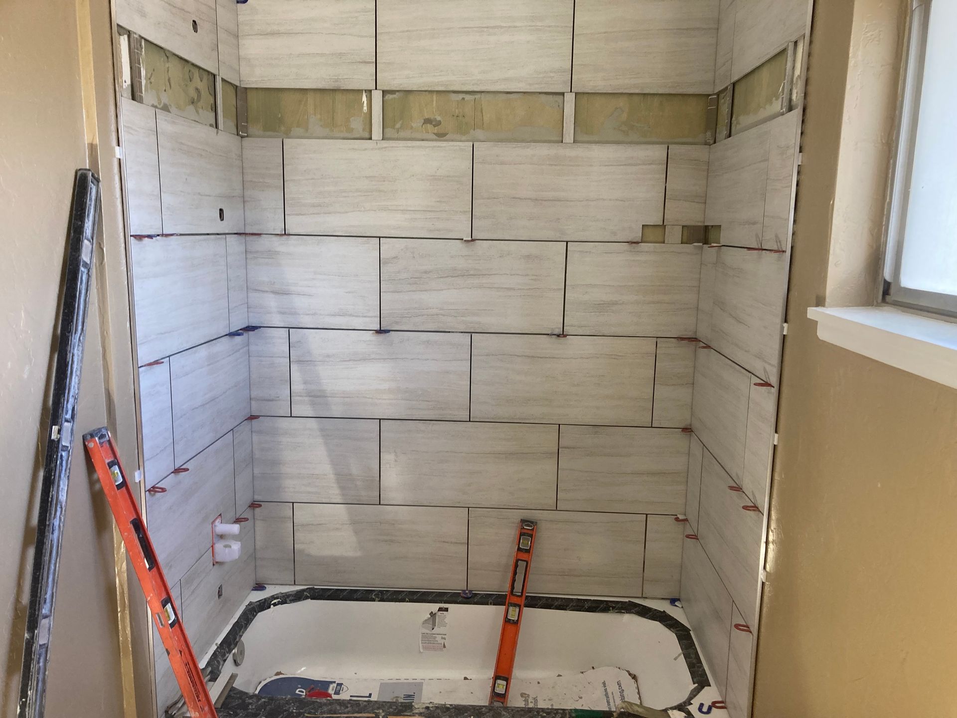 A bathroom under construction with a bathtub and a level.
