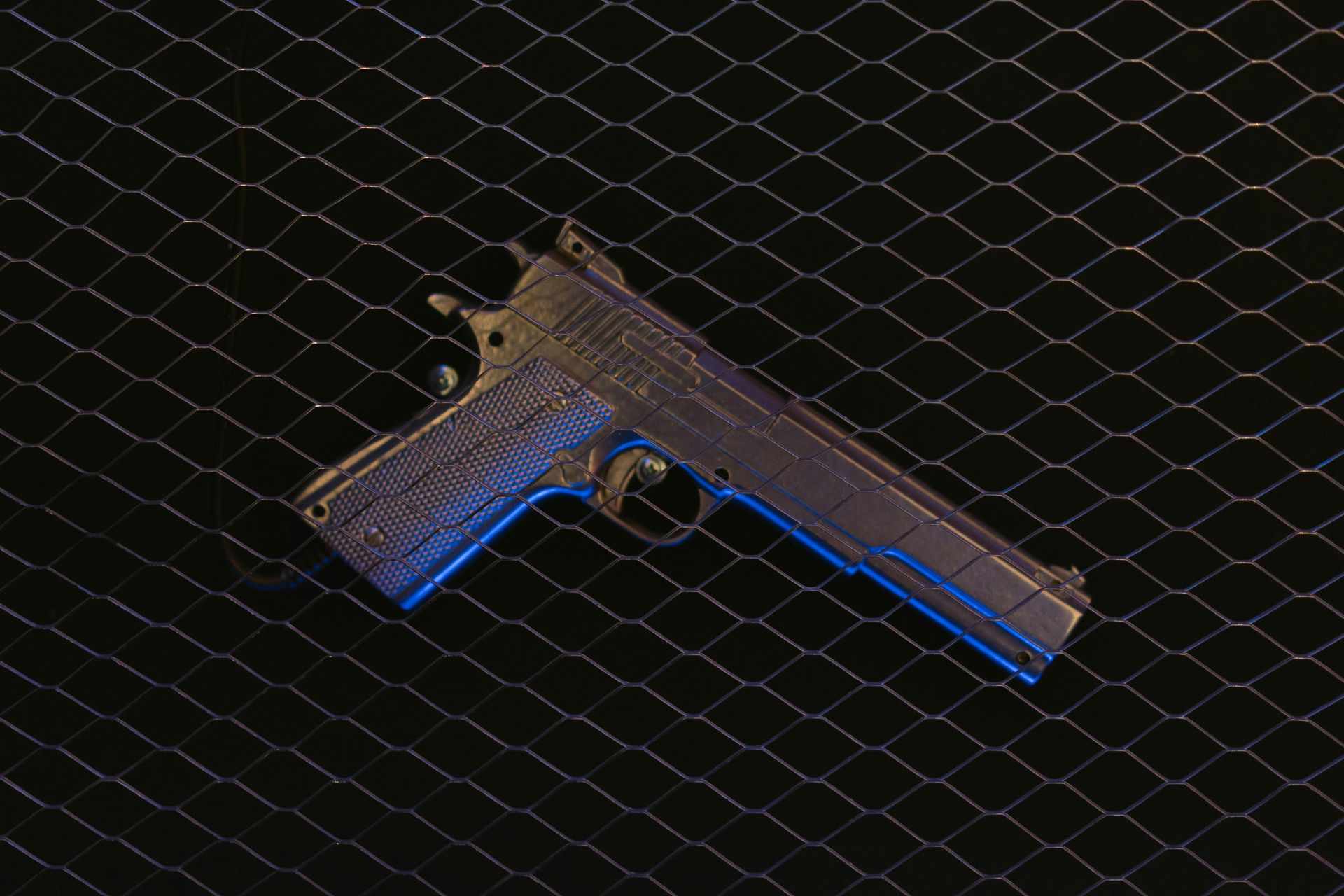 Gun on a mesh background, blue highlights.