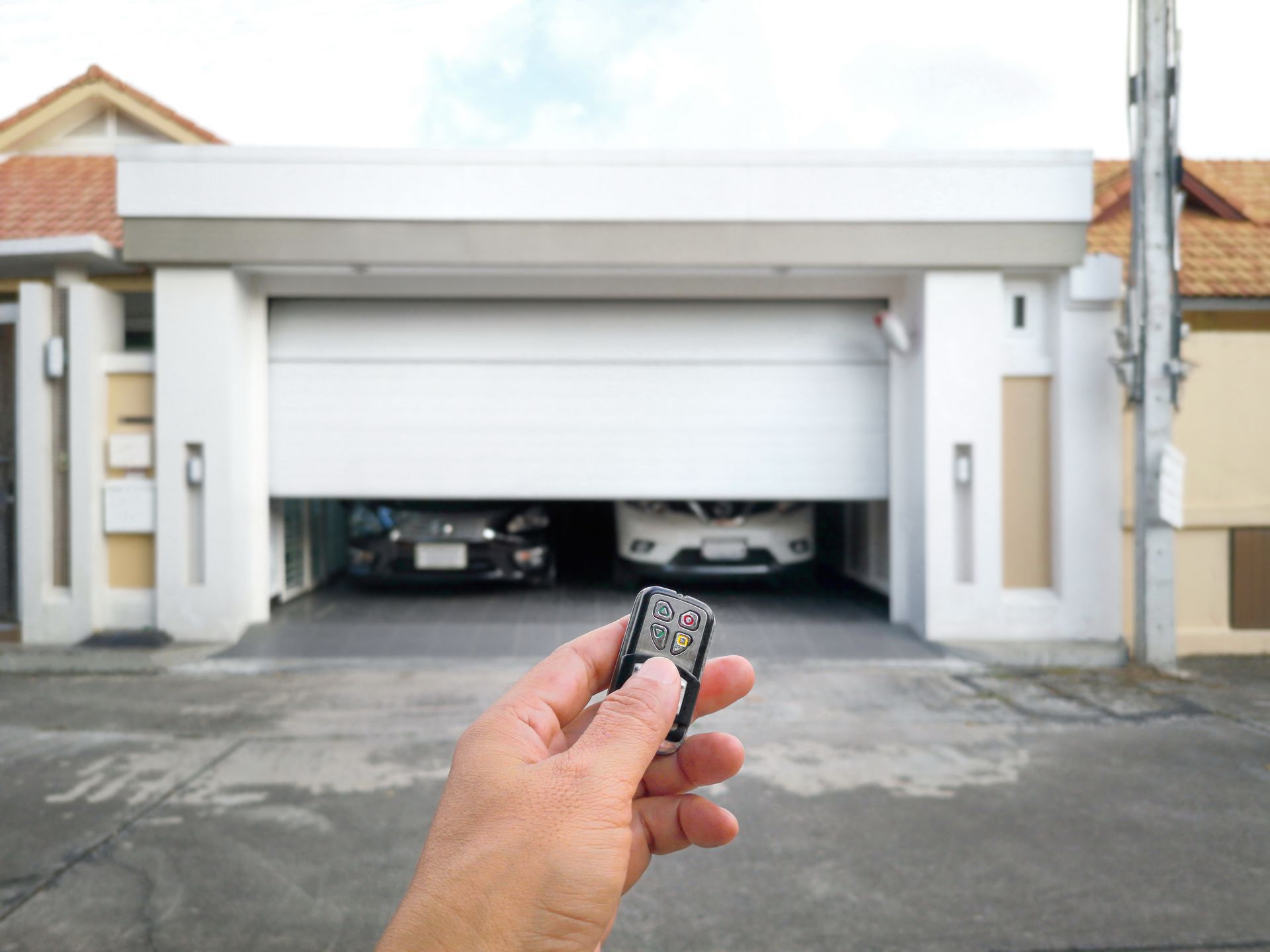 Hand holding a remote control to open a sliding door.