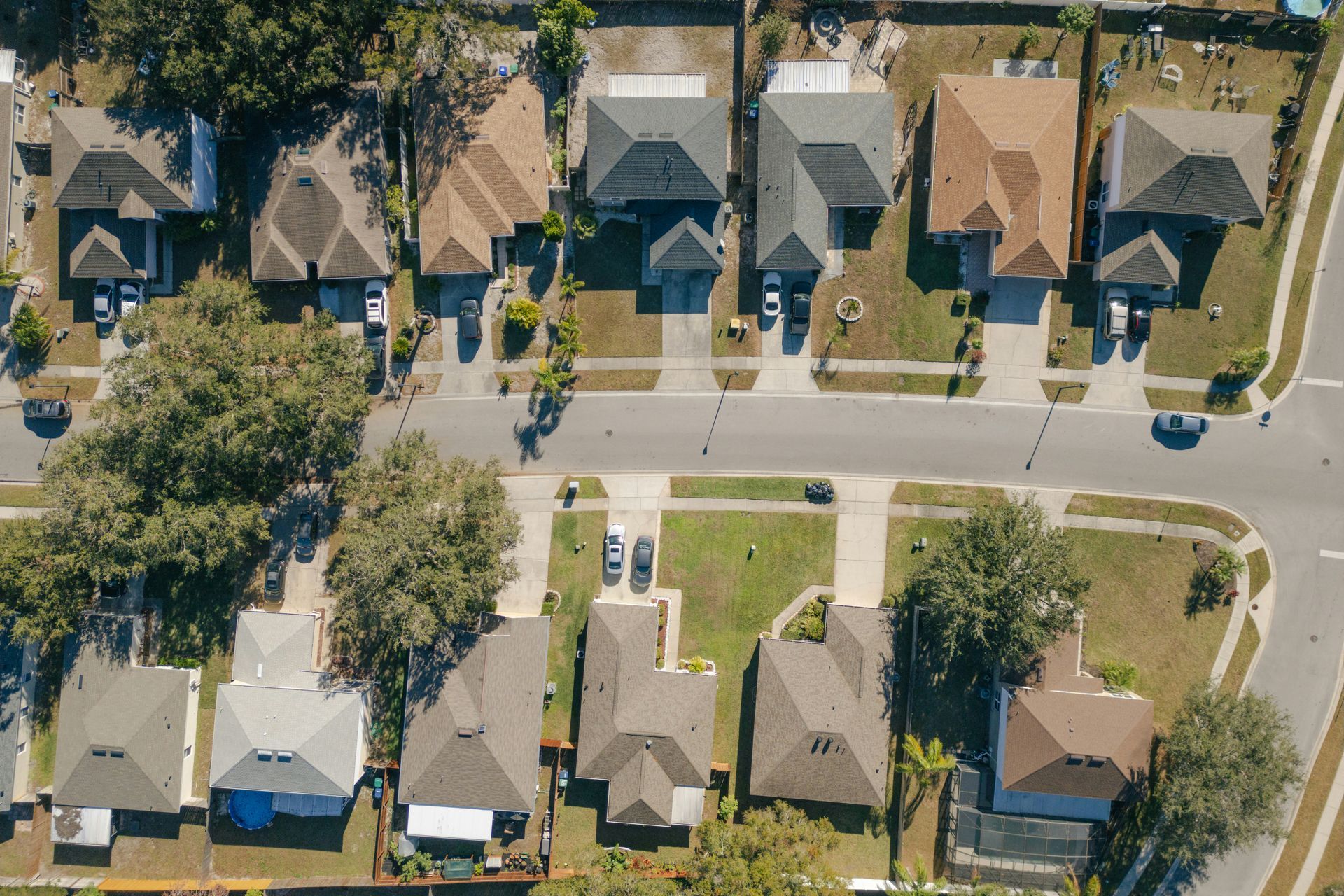 Aerial view of suburban houses with driveways and streets.