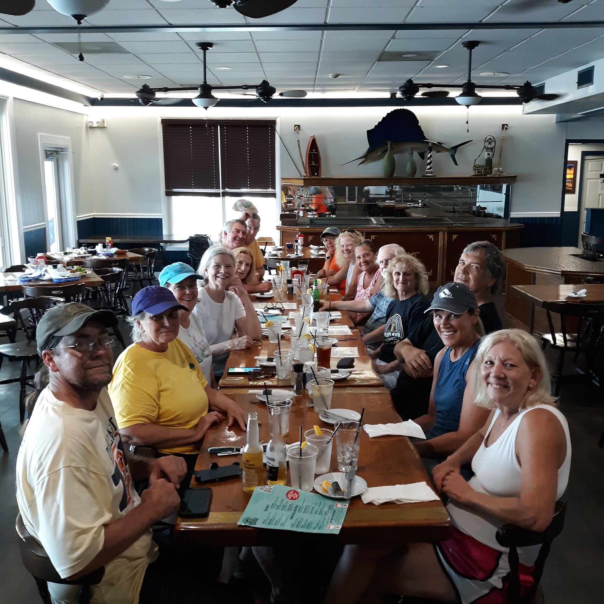 A group of people are sitting at a long table in a restaurant.