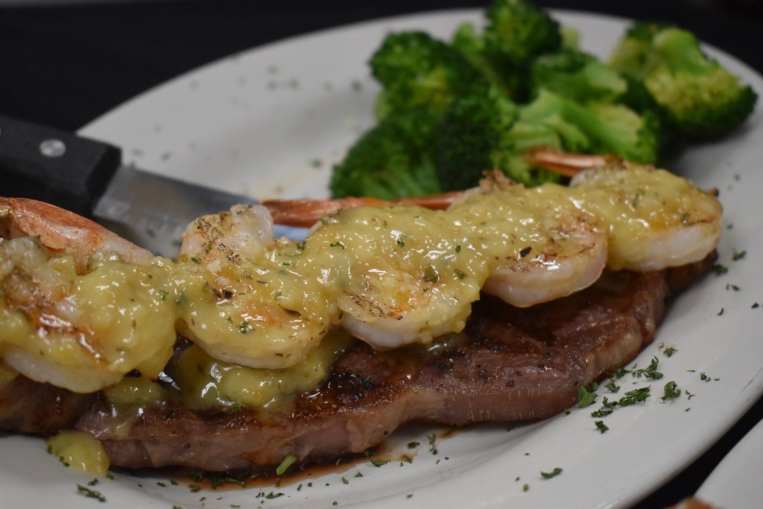 A close up of a plate of food with shrimp and broccoli on it.