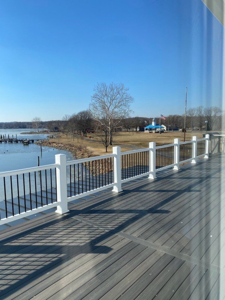 A view of a lake from a deck with a white railing