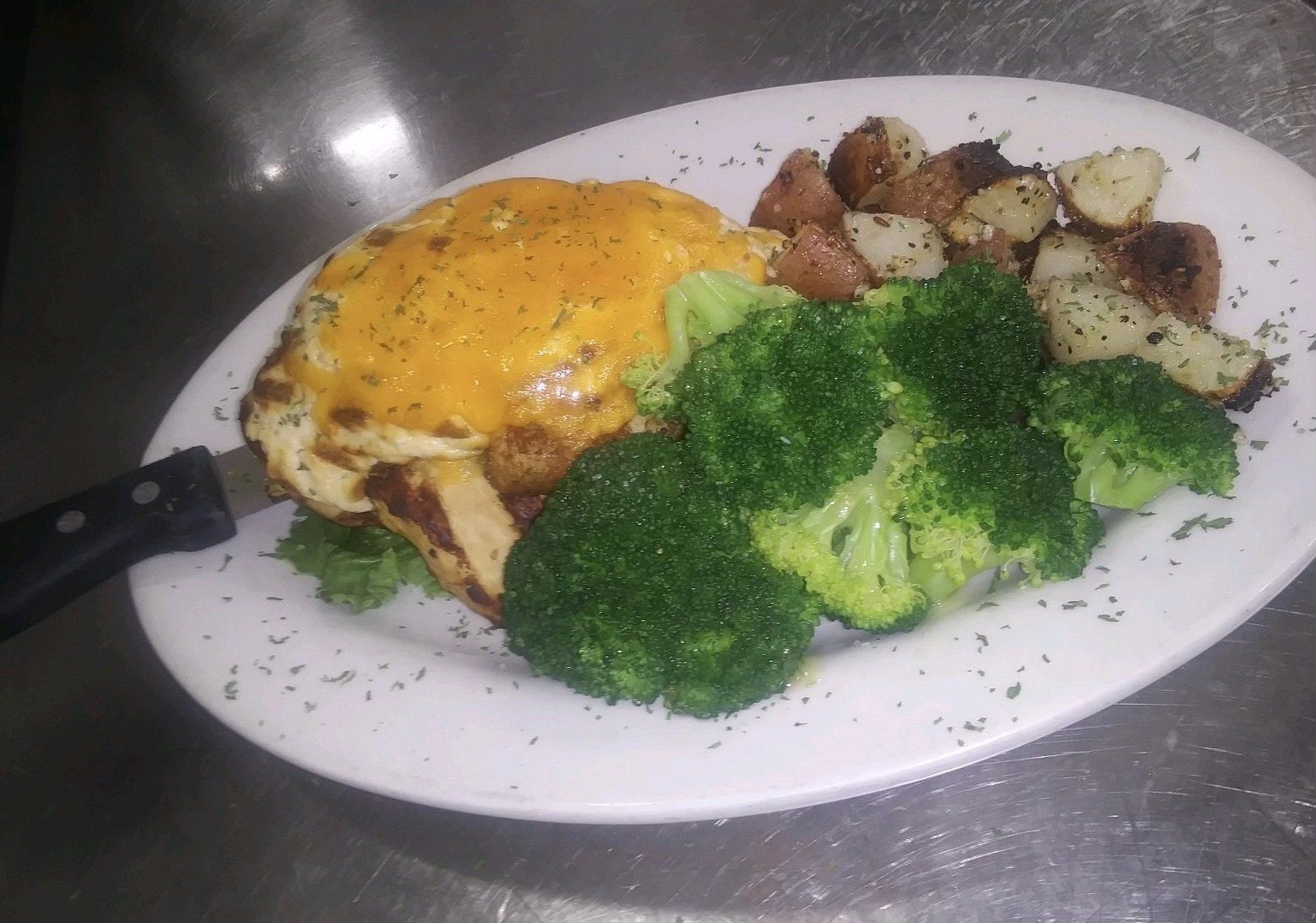 A plate of food with broccoli and potatoes on a table