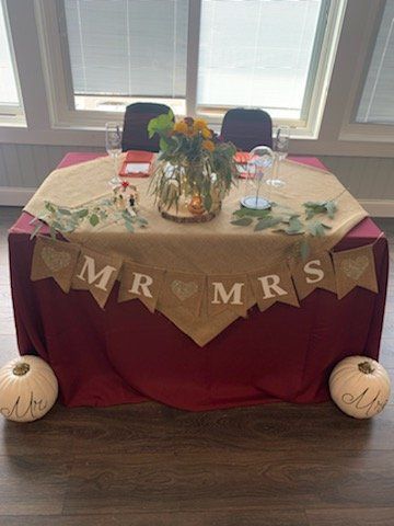 A table with a red table cloth and a banner that says `` mr. and mrs. ''