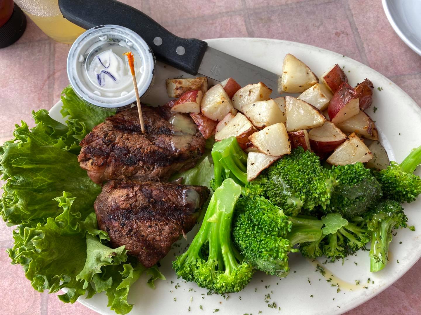 A plate of food with broccoli and potatoes on a table