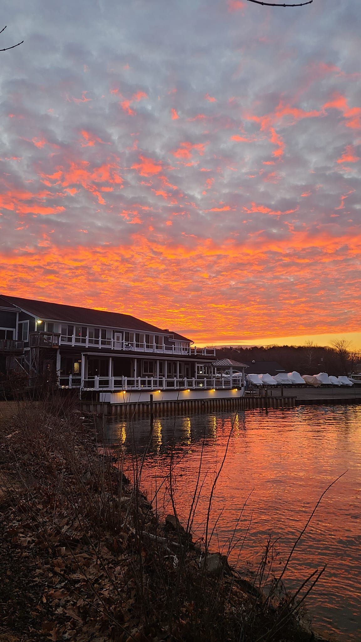 A sunset over a body of water with a dock in the foreground.