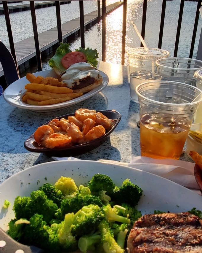 A table topped with plates of food including broccoli and shrimp