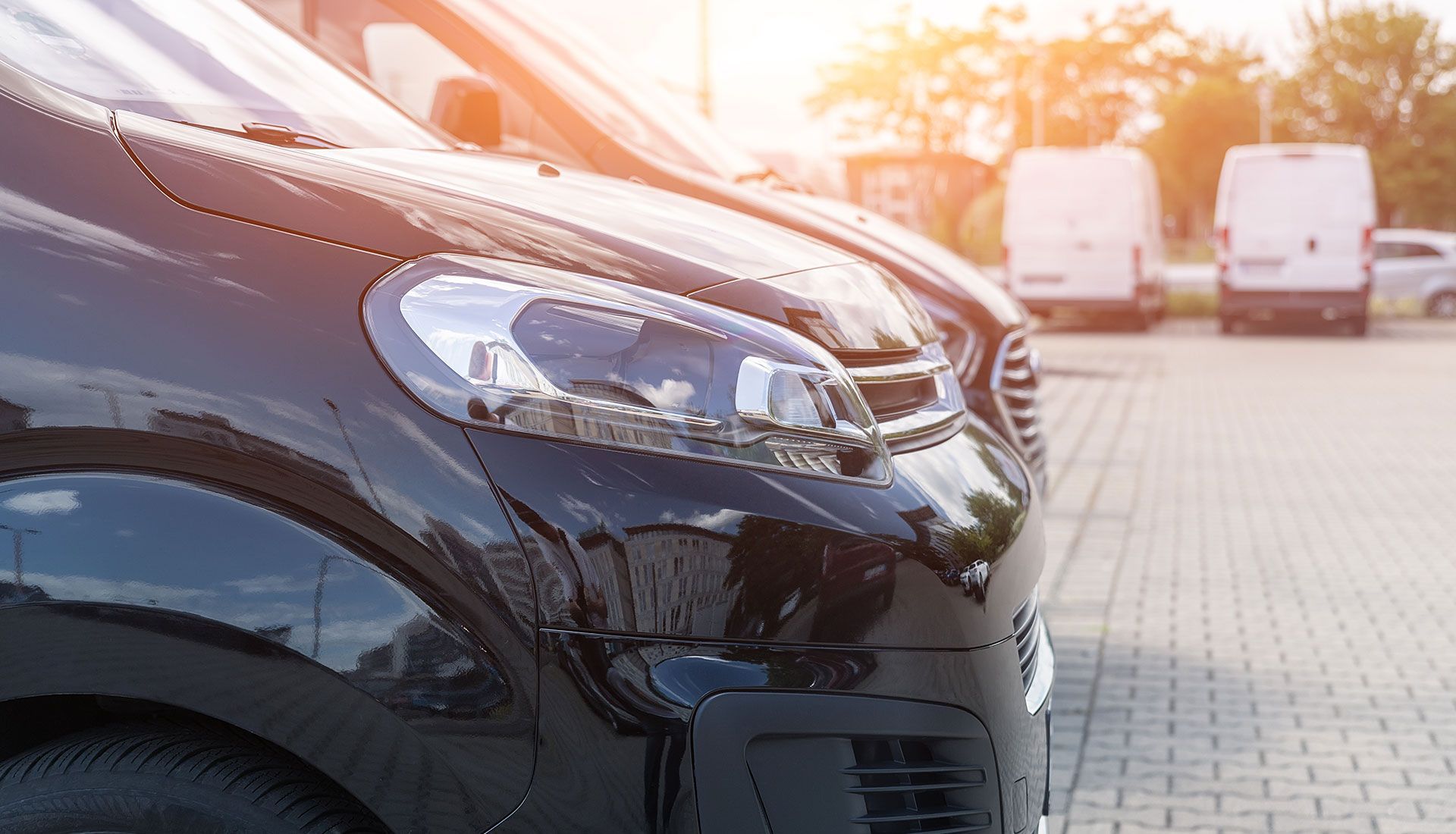 Person painting the trim of a house window, wearing white clothing, sunny day.