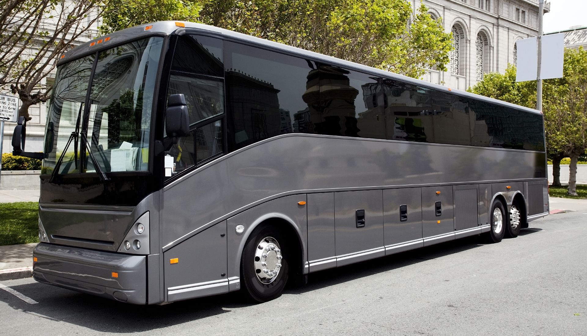 Person painting the trim of a house window, wearing white clothing, sunny day.