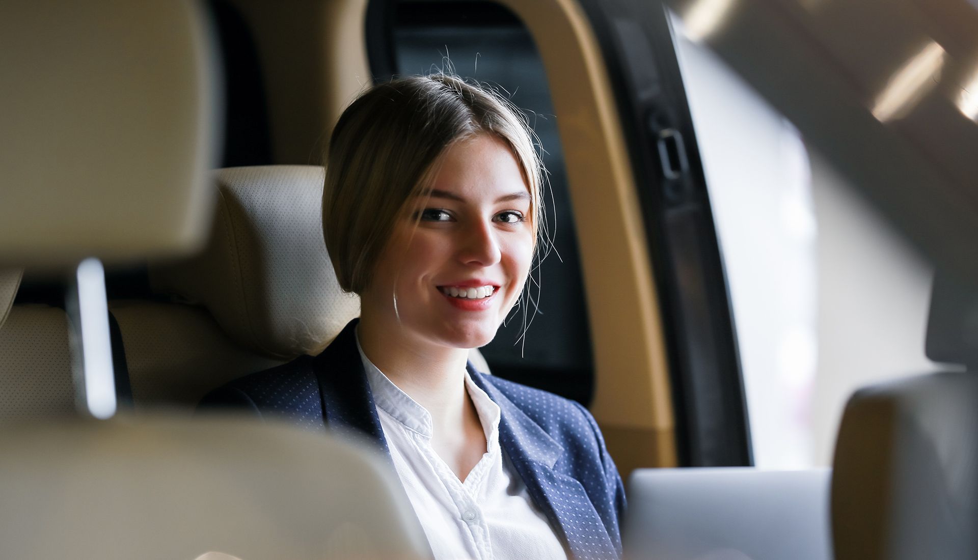 Person painting the trim of a house window, wearing white clothing, sunny day.