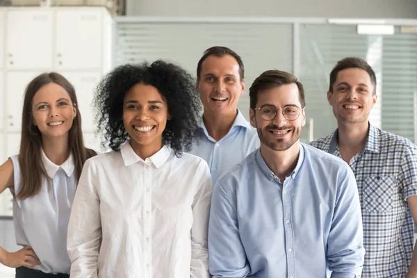 A group of people are posing for a picture together and smiling.