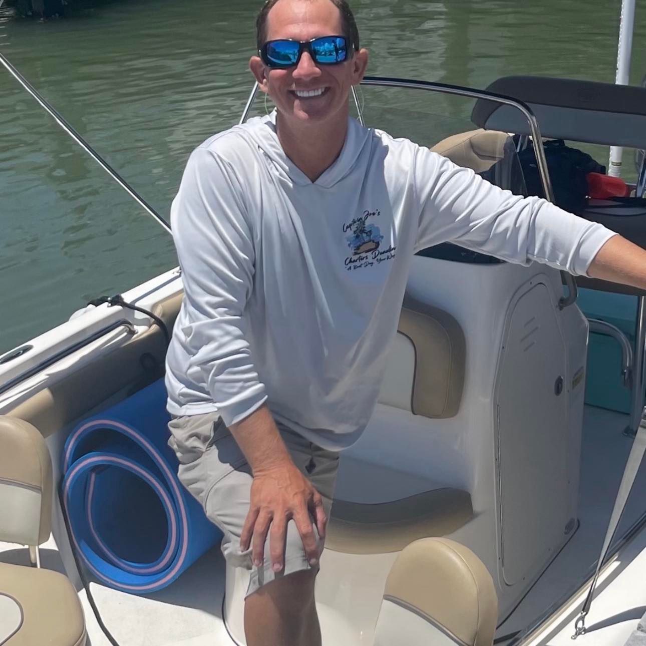A man wearing sunglasses is sitting on a boat