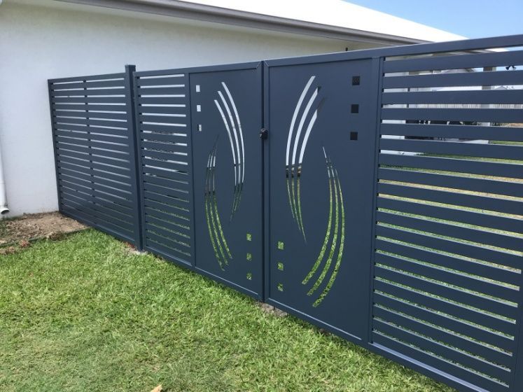A Black Fence With A Design On It Is In Front Of A House— Ward's Aluminium in Garbutt, QLD