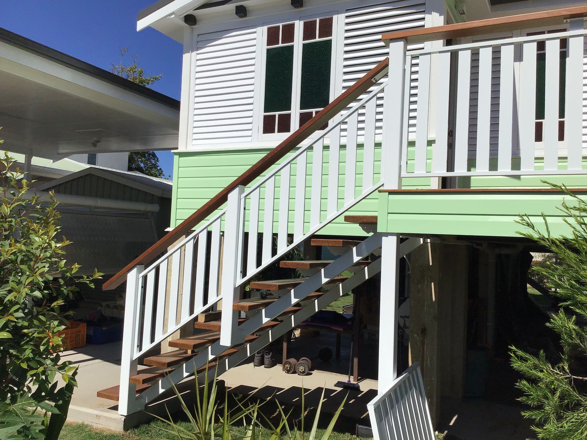 A White and Green House With Stairs Leading Up To It — Ward's Aluminium in Ingham, QLD