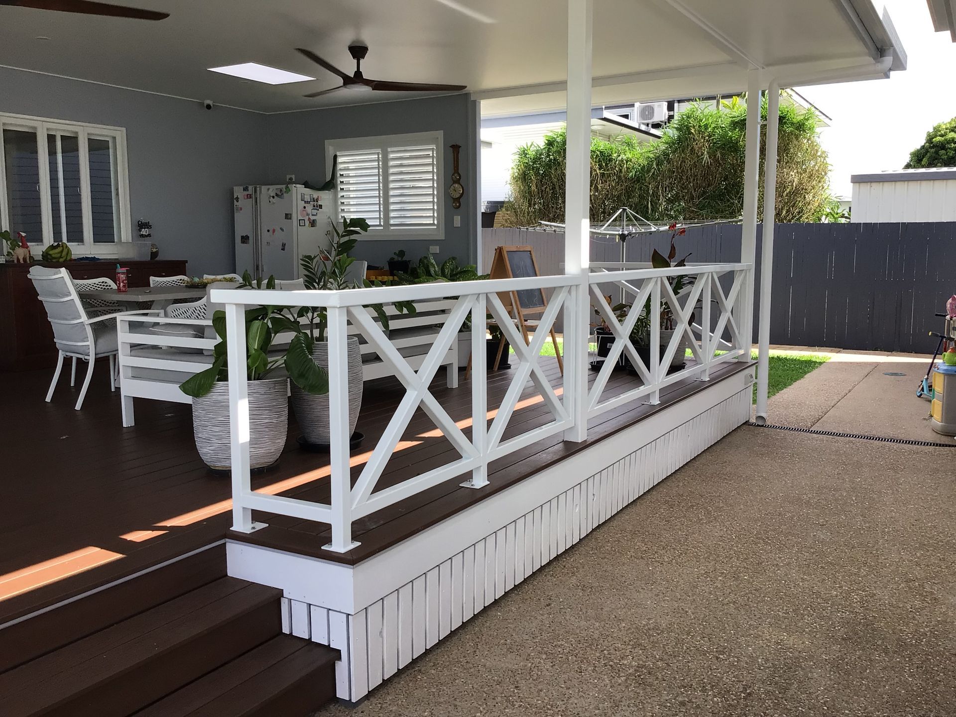 A White Gated Outside Area on Brown Tiled Floor— Ward's Aluminium in Garbutt, QLD
