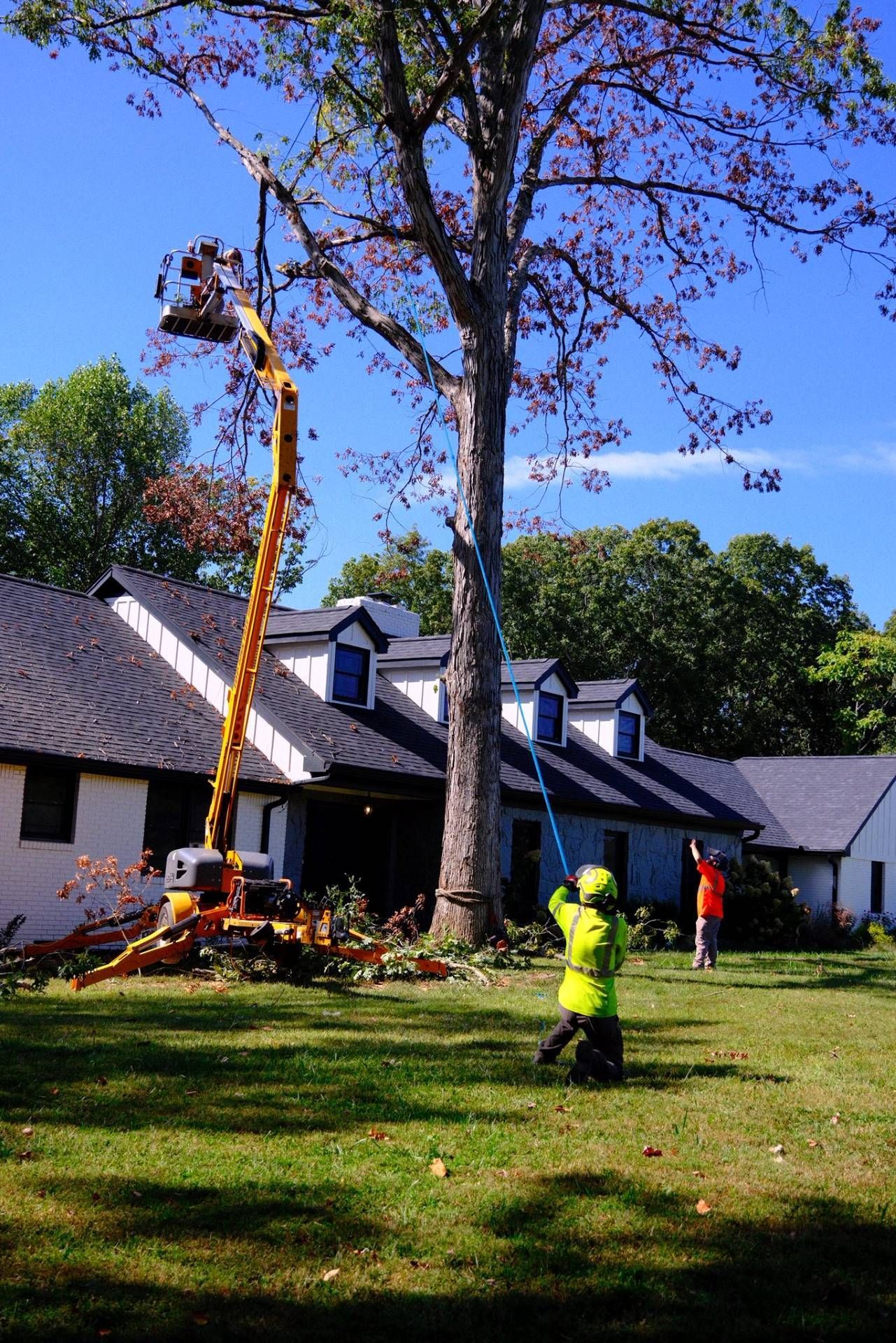 Woman in straw hat smiles, holding wine glass near a lake.