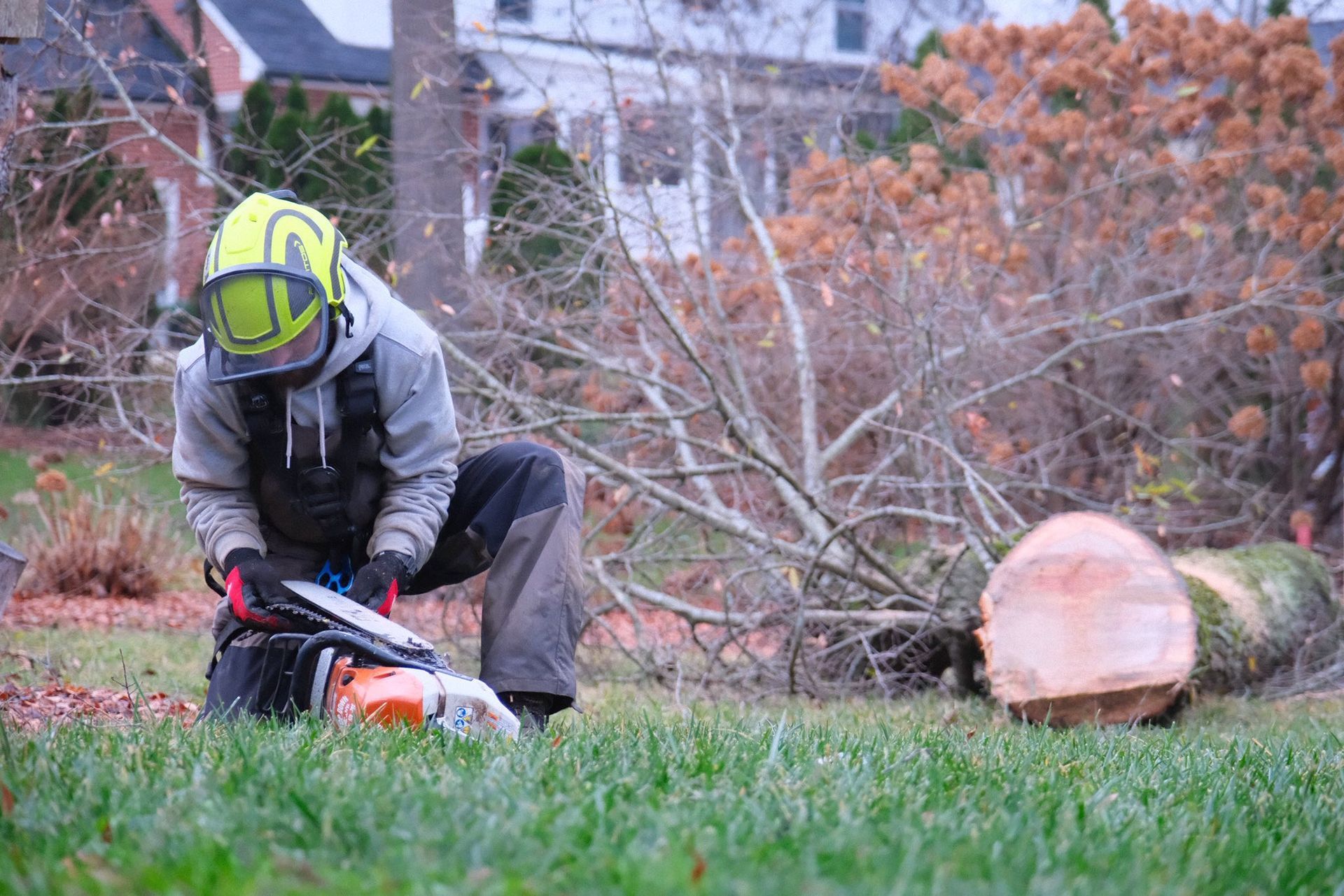Woman in straw hat smiles, holding wine glass near a lake.