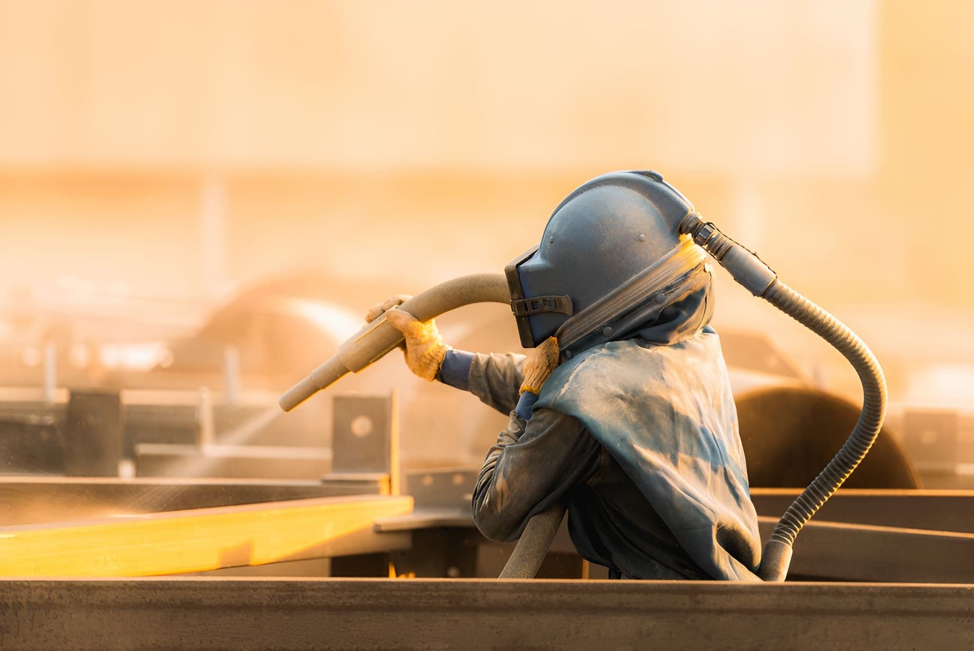 A Person is Sandblasting a Piece of Metal in a Factory — Veramax Industries in Gladstone, QLD