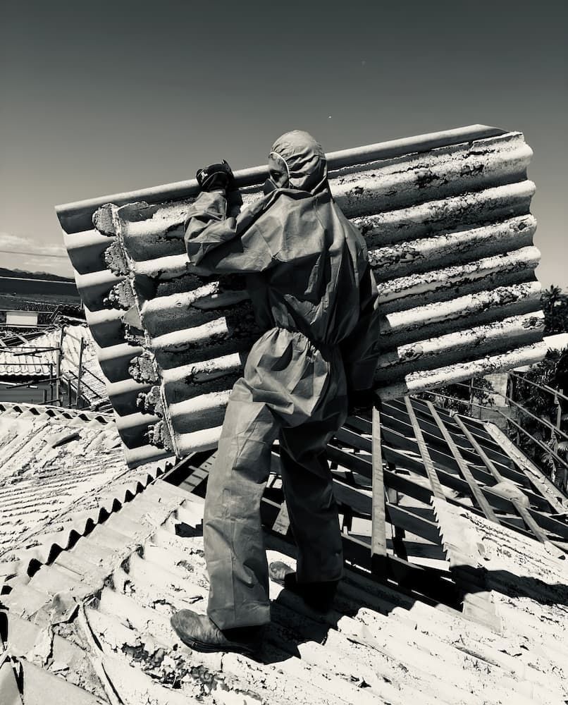 A Black and White Photo of a Man Carrying a Stack of Logs — Veramax Industries in Park Avenue, QLD