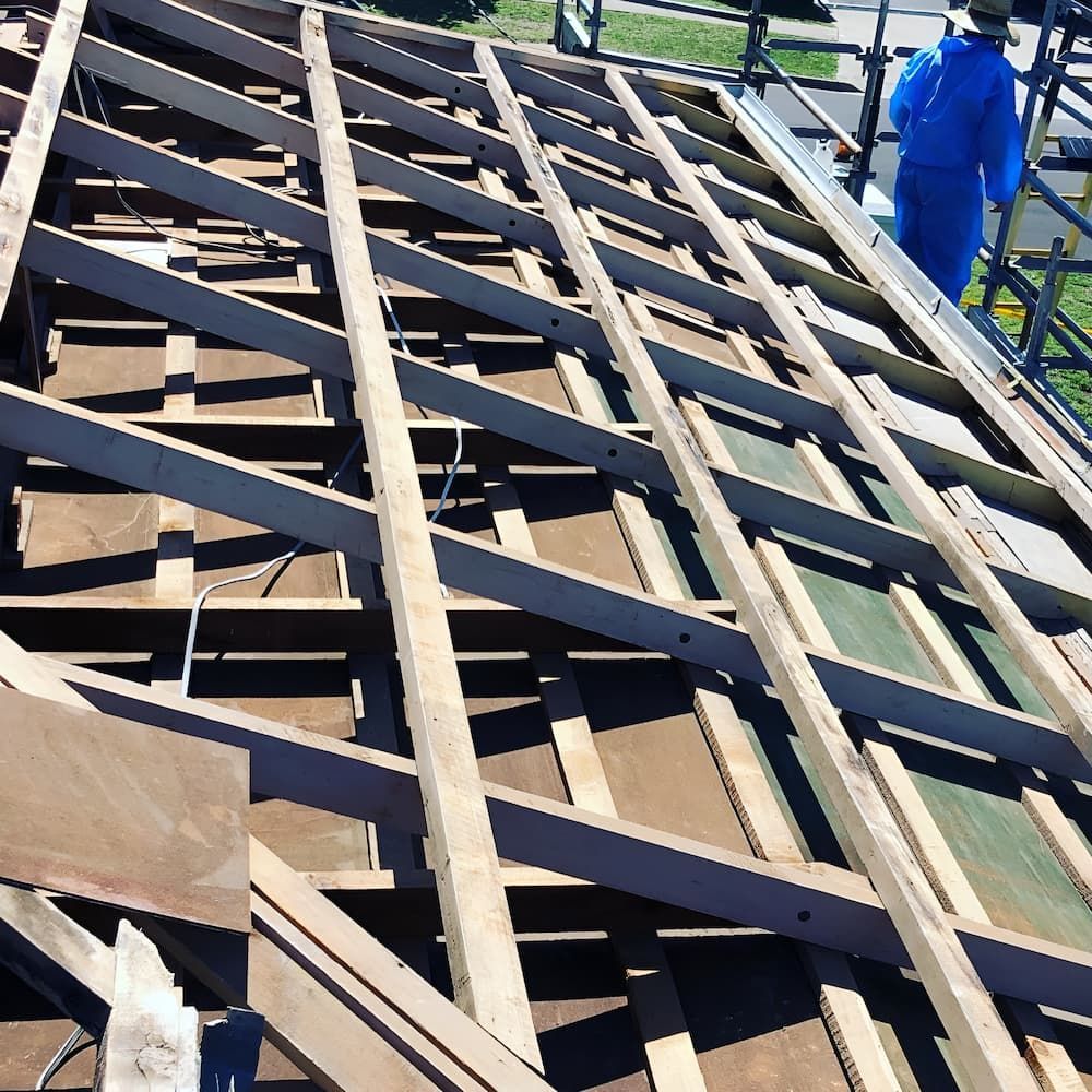 A Man in a Blue Jacket is Working on a Wooden Structure — Veramax Industries in Park Avenue, QLD