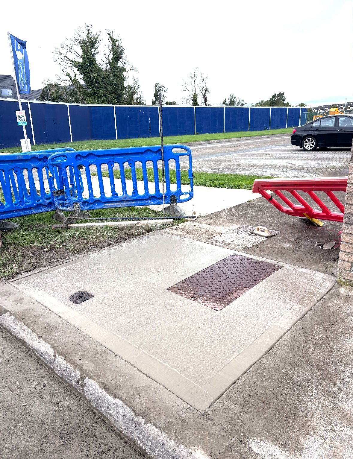 A construction worker is spreading asphalt on a road with a shovel.
