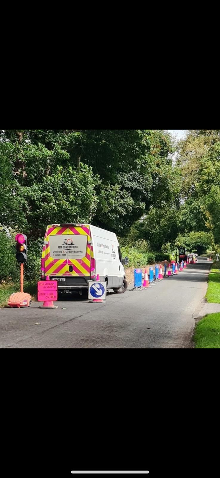 A white van is parked on the side of a road.