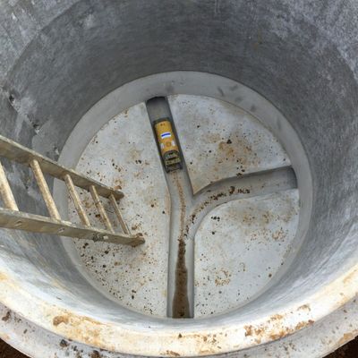 A ladder is going up into a hole with a level in it