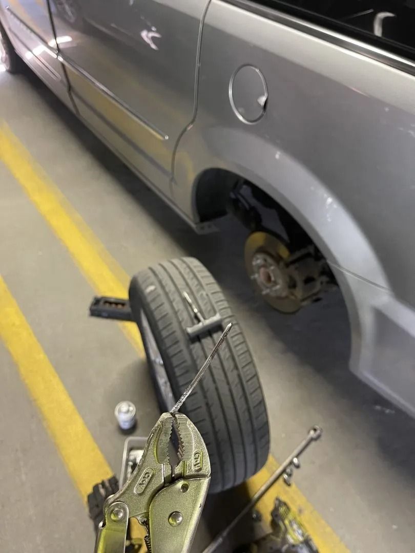 A car with a tire chained to it in a parking lot