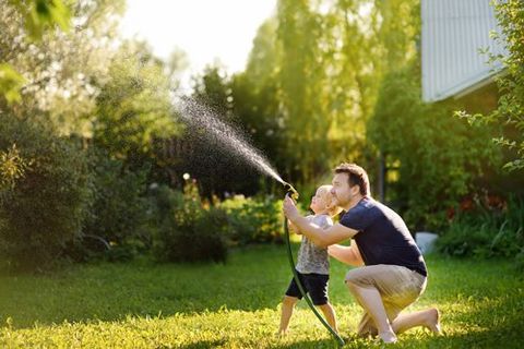 Father and Son Playing Water on the Lawn — Oldsmar, FL — The Spray Doctor