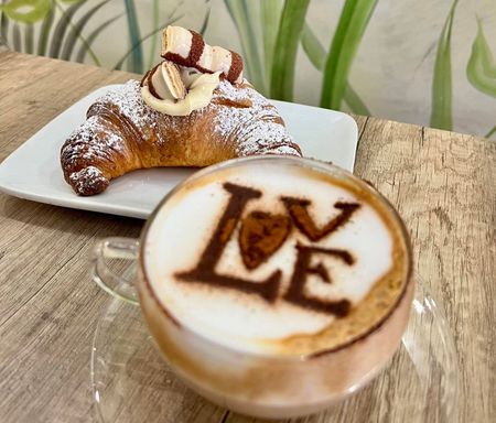 Un ristorante con tavoli e sedie e una vetrina con prodotti alimentari.