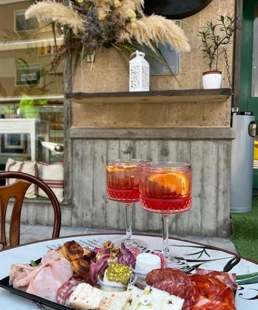Un tavolo con sopra una bevanda e un bicchiere di vino