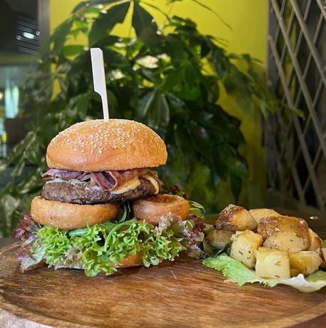 Un ristorante con tavoli e sedie e una vetrina con prodotti alimentari.