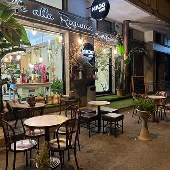 Un ristorante con tavoli e sedie e un bar sullo sfondo.