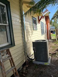 Yellow house exterior with air conditioning unit.