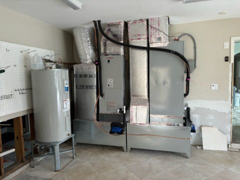 HVAC system and water heater in a garage. Grey metal units with insulated ductwork.