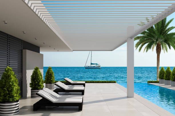 Luxury louvered roof overlooking oceanfront pool.