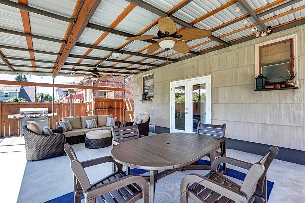 Large wood-paneled patio cover with ceiling fan and table.