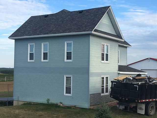 A house with a dumpster in front of it