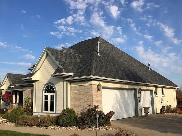A large house with a gray roof and a white garage door.