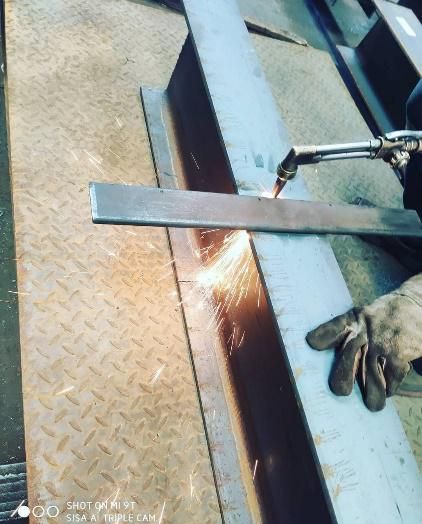 Una persona está cortando un trozo de metal con un soplete.