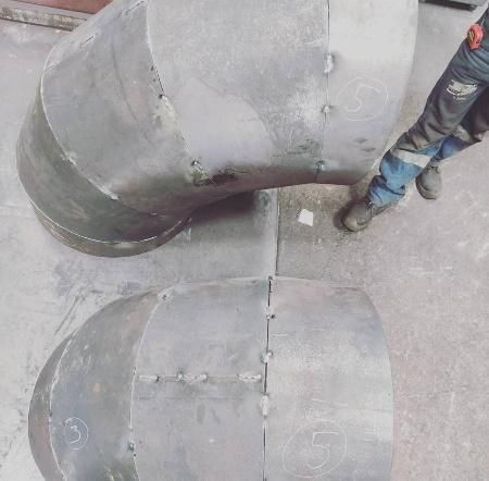 Un hombre está de pie junto a un gran tubo de metal.