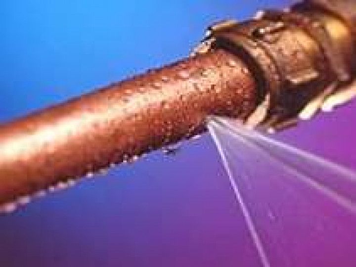 a close up of a copper pipe with water coming out of it